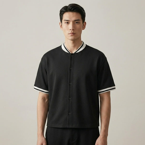 Black oversized baseball jersey with a button front and white striped collar and cuffs, front view.