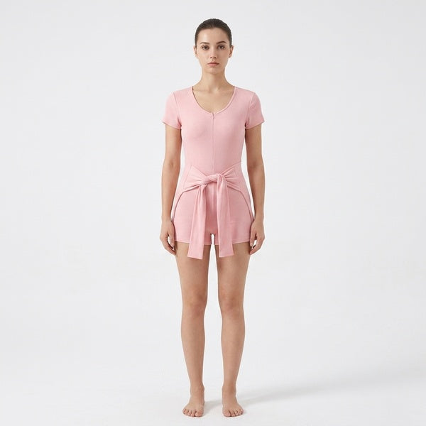 Pink short-sleeve tie-waist romper with the cape panel tied at the front, full-length front view.