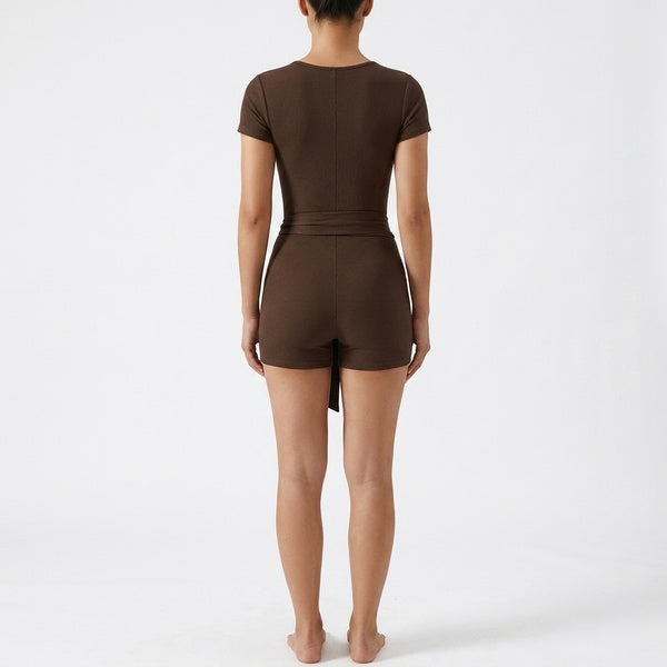 Back of the brown short-sleeve tie-waist romper showing the fitted waist and shorts.
