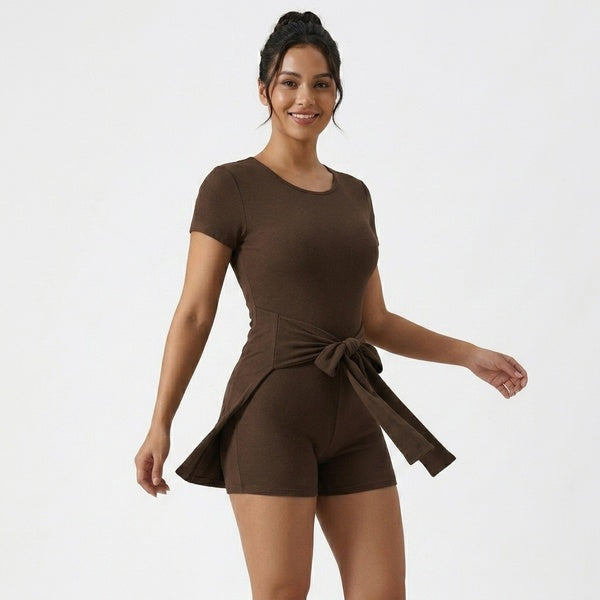Brown tie-waist romper with the cape panel moving outward, three-quarter front view.