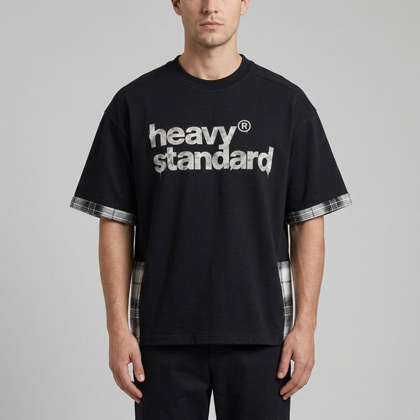 Black plaid paneled T-shirt with dropped shoulders and plaid sleeve trim, close front view on a model.