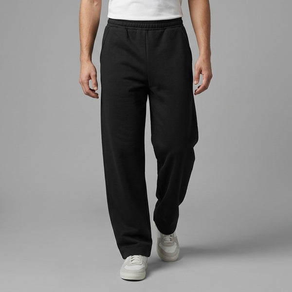 Black barrel leg sweatpants styled with a white T-shirt and sneakers, walking front view.