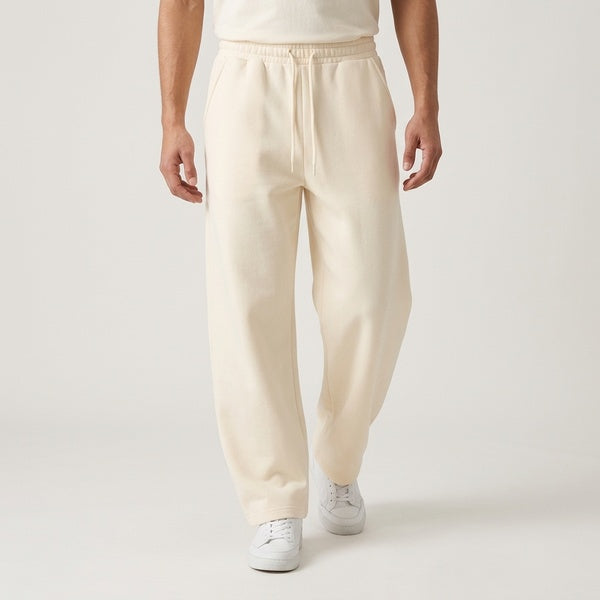 Cream barrel leg sweatpants styled with white sneakers, walking front view.