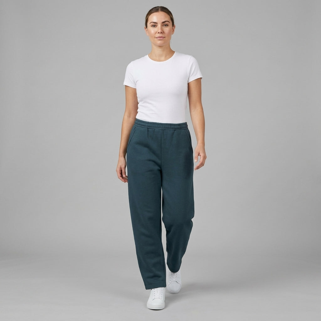 Dark teal unisex barrel leg sweatpants styled with a white T-shirt and sneakers, walking front view.