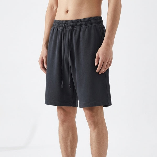Black vintage wash cotton shorts with a drawstring waist and side pockets, three-quarter front view on a model.