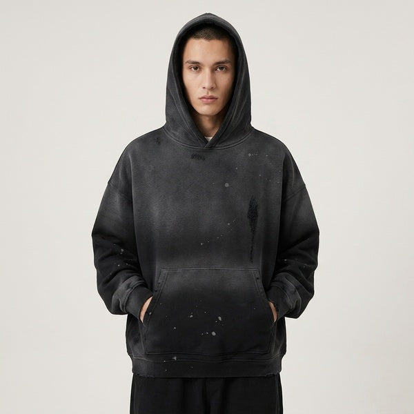Front view of the black Vintage Wash Frayed Fleece Hoodie worn with the hood up and hands in the pocket.