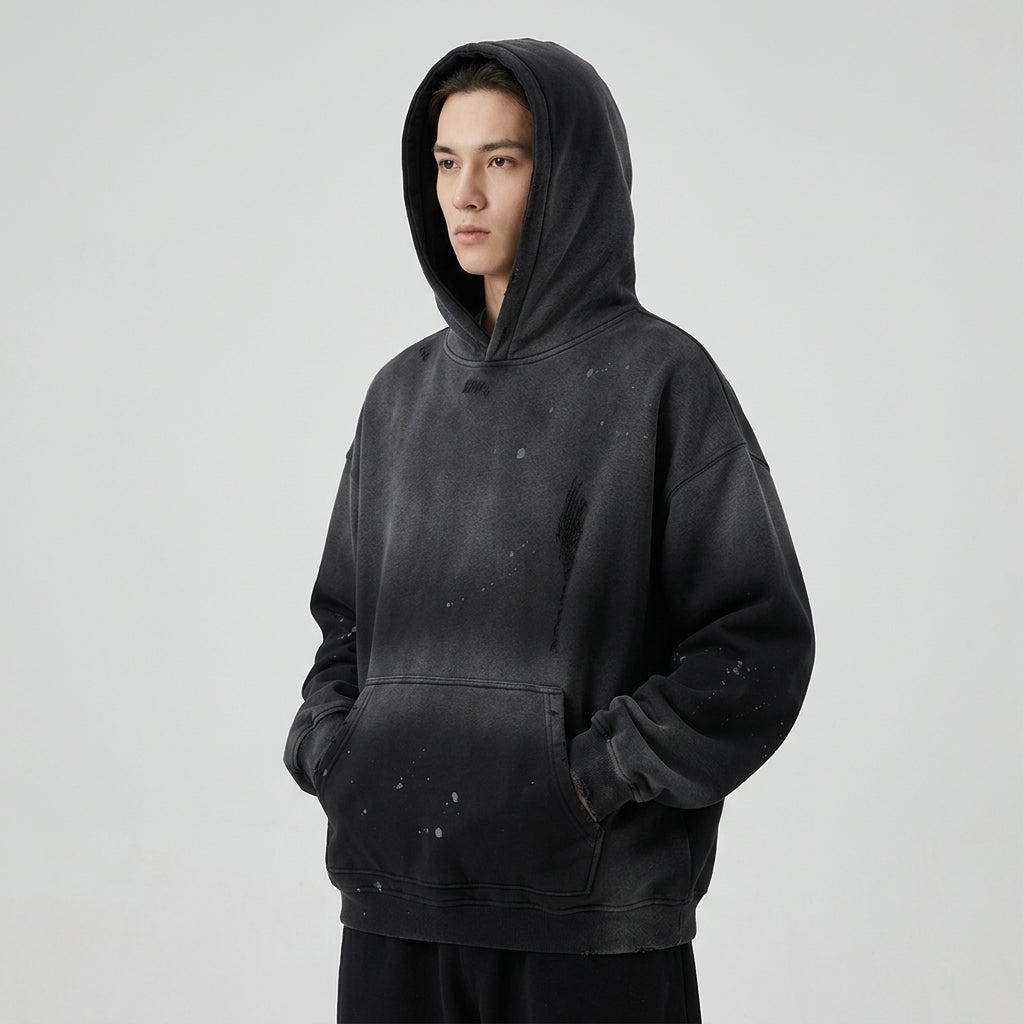 Angled view of the black Vintage Wash Frayed Fleece Hoodie worn with the hood up.