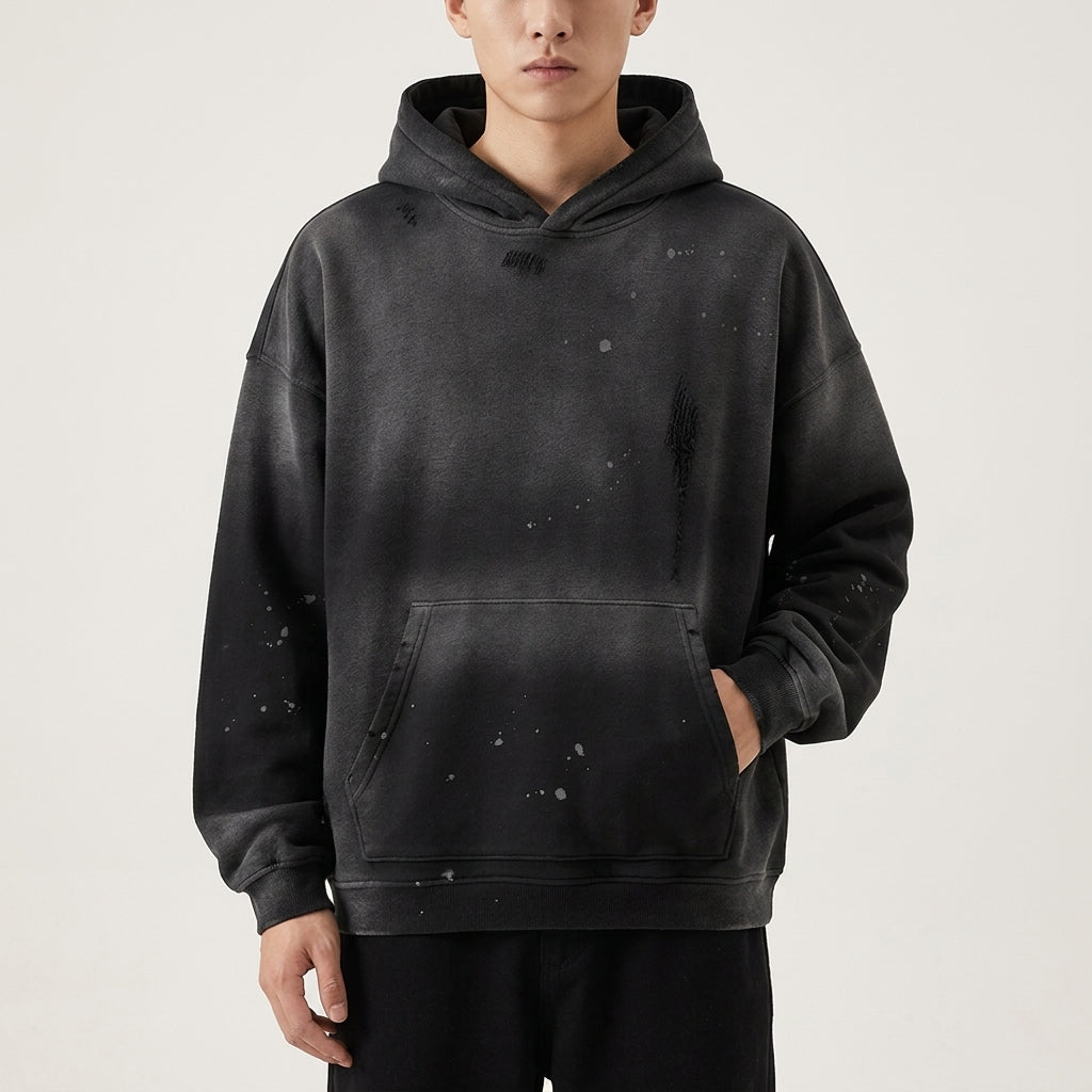 Black Vintage Wash Frayed Fleece Hoodie worn with the hood down, showing the washed front and pocket.