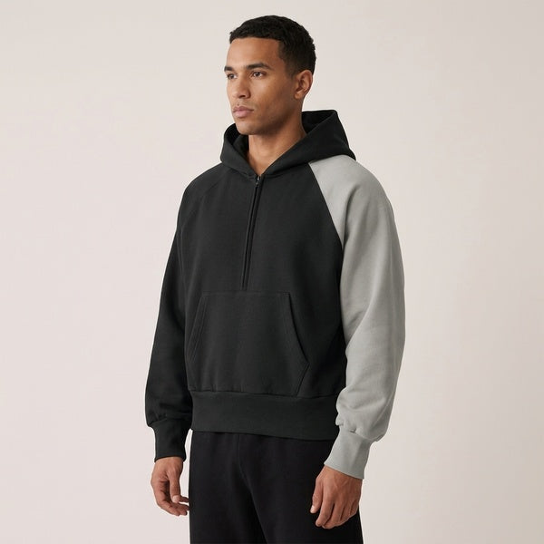 Black and gray Unisex Color-Block Fleece Hoodie worn in an angled front view, showing the quarter zip.