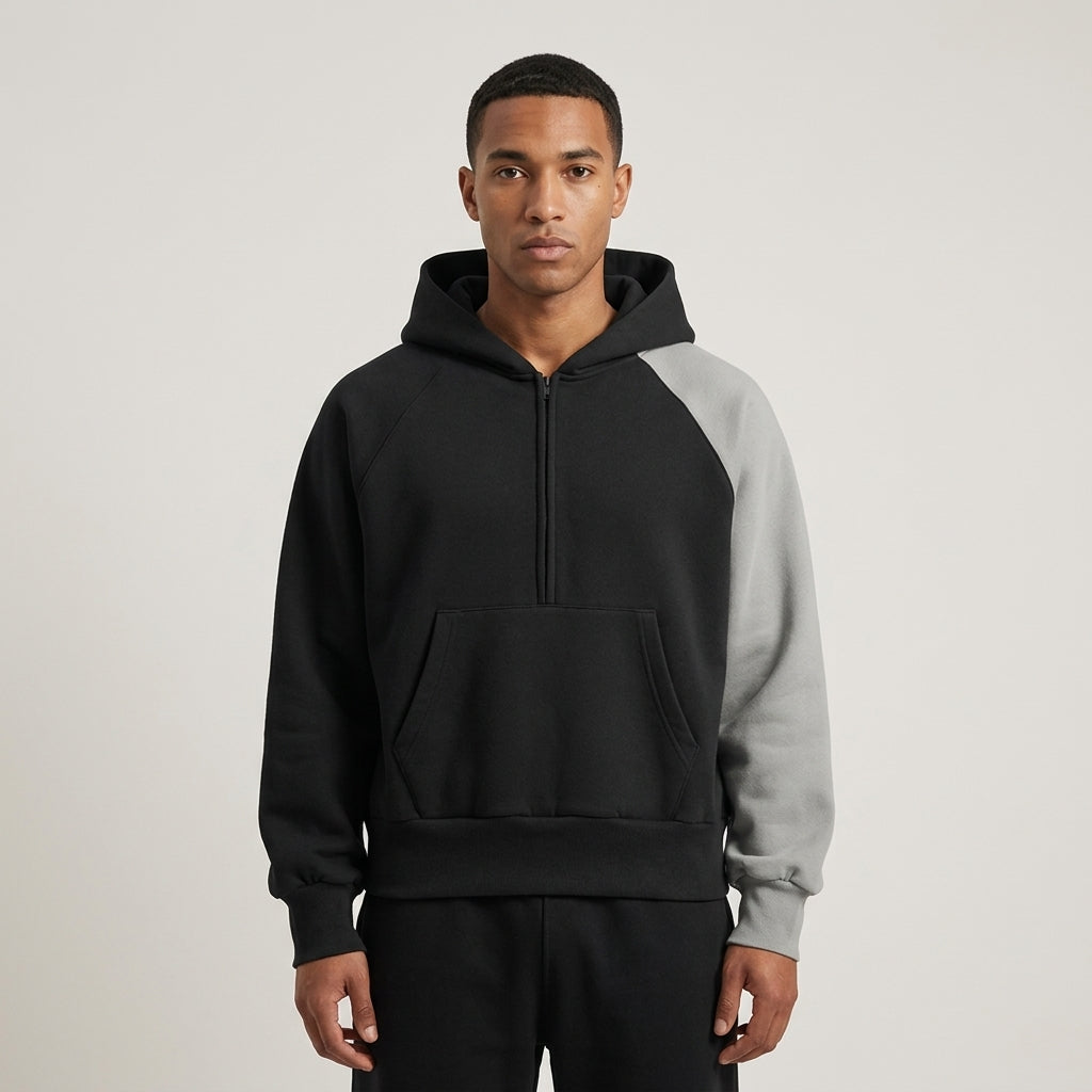 Front view of the black and gray Unisex Color-Block Fleece Hoodie on a model.