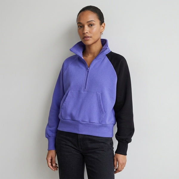 Purple and black Unisex Color-Block Fleece Hoodie worn with the hood down and black pants.