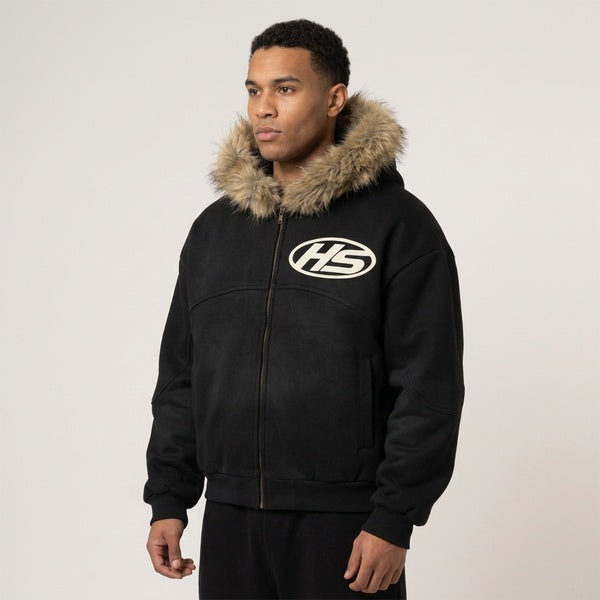 Angled view of the black Sun Fade Boxy Detachable Fur Hoodie worn with black pants.