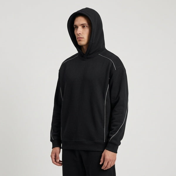 Angled view of the black Unisex Oversized Piping Fleece Hoodie worn with the hood up.