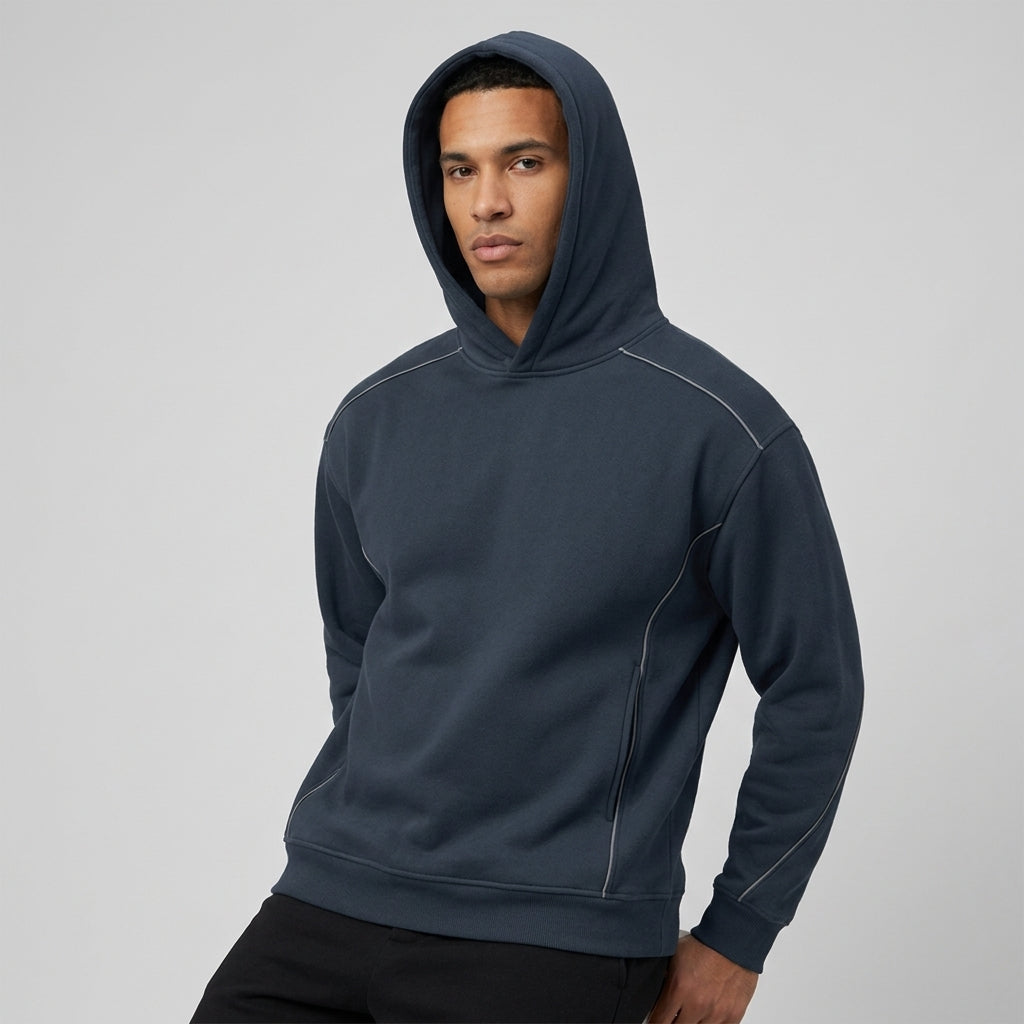 Navy oversized piping fleece hoodie, model in a three-quarter front view with the hood up.