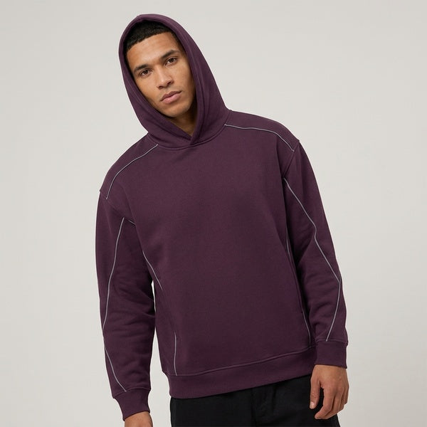 Purple oversized piping fleece hoodie, model in a three-quarter front view with the hood up.