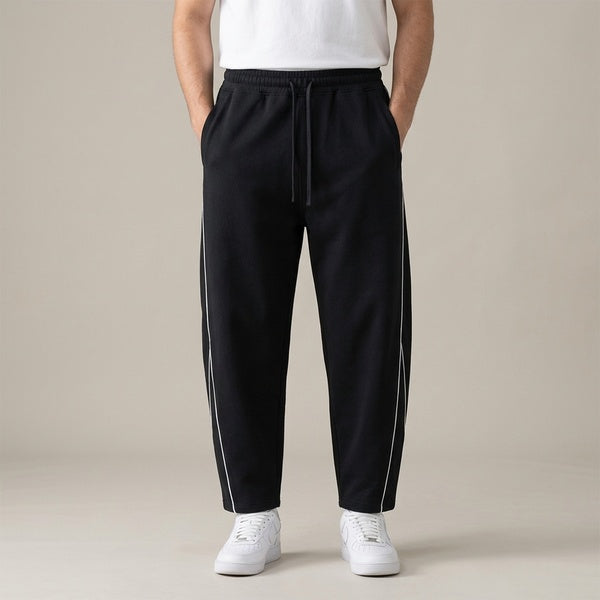 Black piping fleece barrel-leg sweatpants, model in a straight front view.