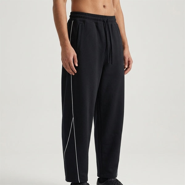 Black piping fleece barrel-leg sweatpants, model in a three-quarter front view.