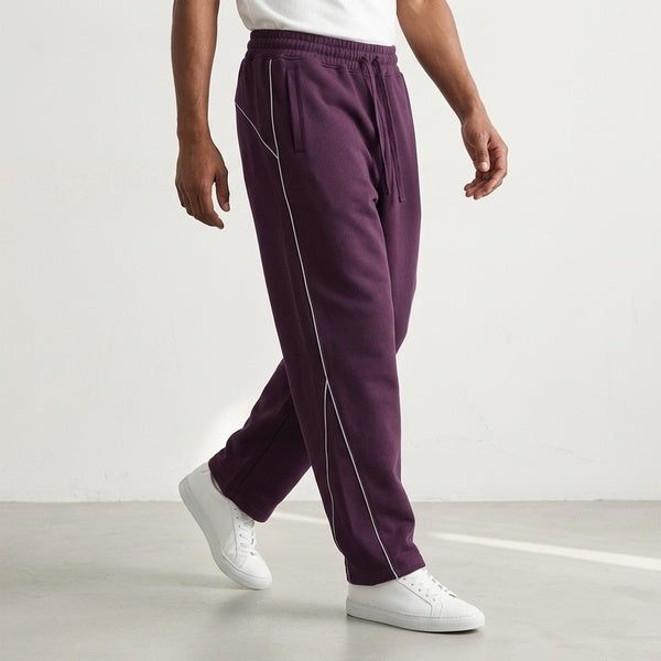 Purple piping fleece barrel-leg sweatpants, model walking in a side view.