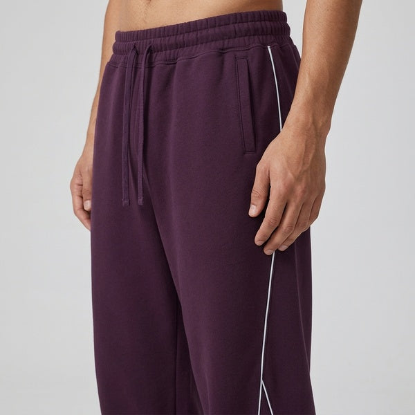 Purple piping fleece sweatpants, close-up of the drawstring waistband and front piping.
