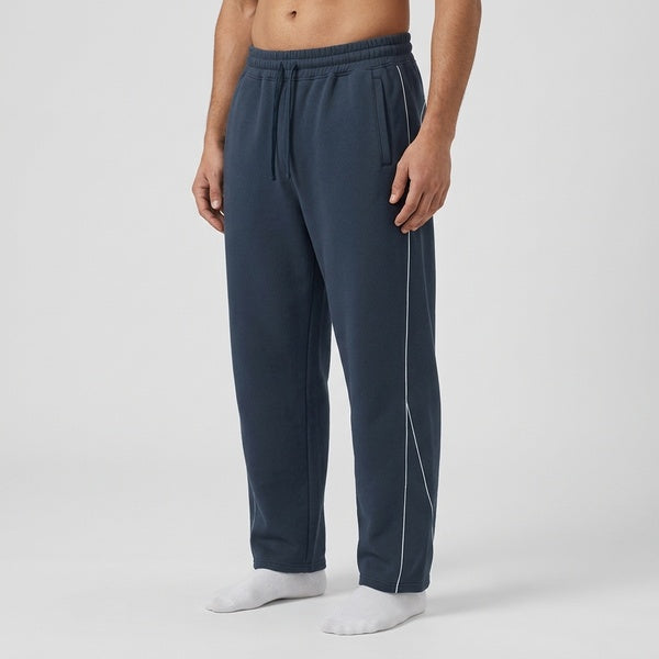 Navy piping fleece barrel-leg sweatpants, model in a three-quarter front view.