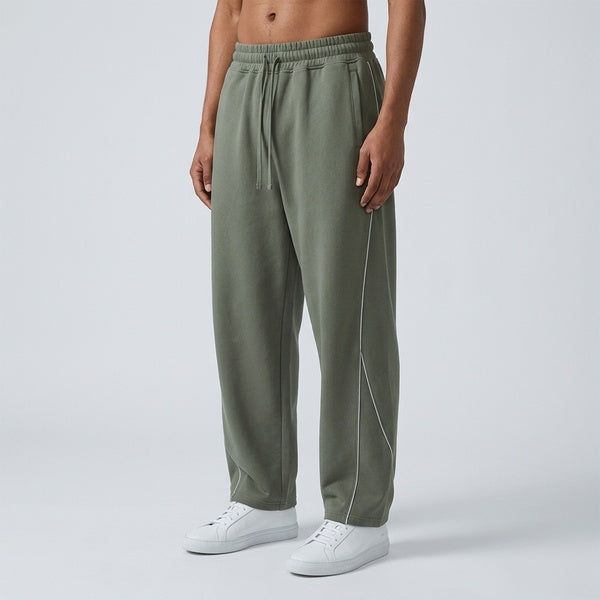 Muted gray-green piping fleece barrel-leg sweatpants, model in a three-quarter front view.