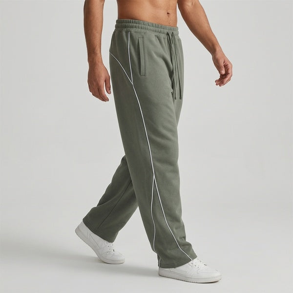 Muted gray-green piping fleece barrel-leg sweatpants, model walking in a side view.