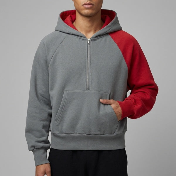 Color-block fleece hoodie in gray and red, cropped front view showing the quarter zip and kangaroo pocket.