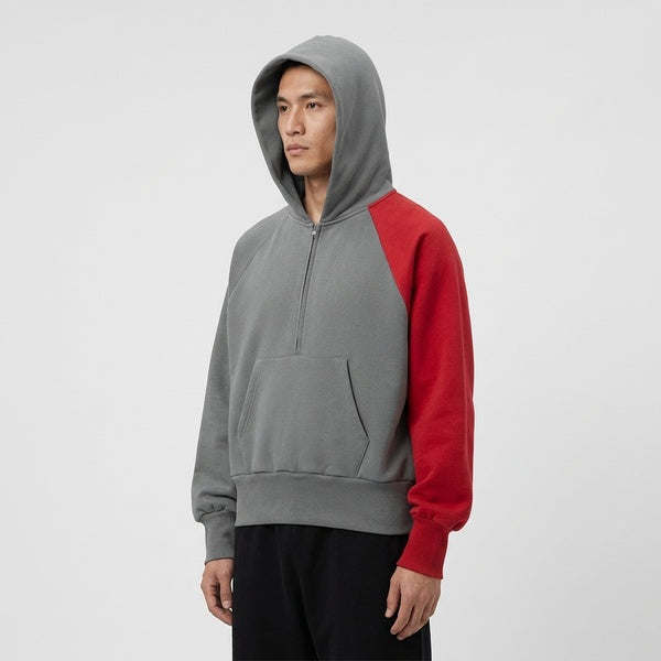 Gray and red color-block fleece hoodie, model in a three-quarter front view with the hood up.