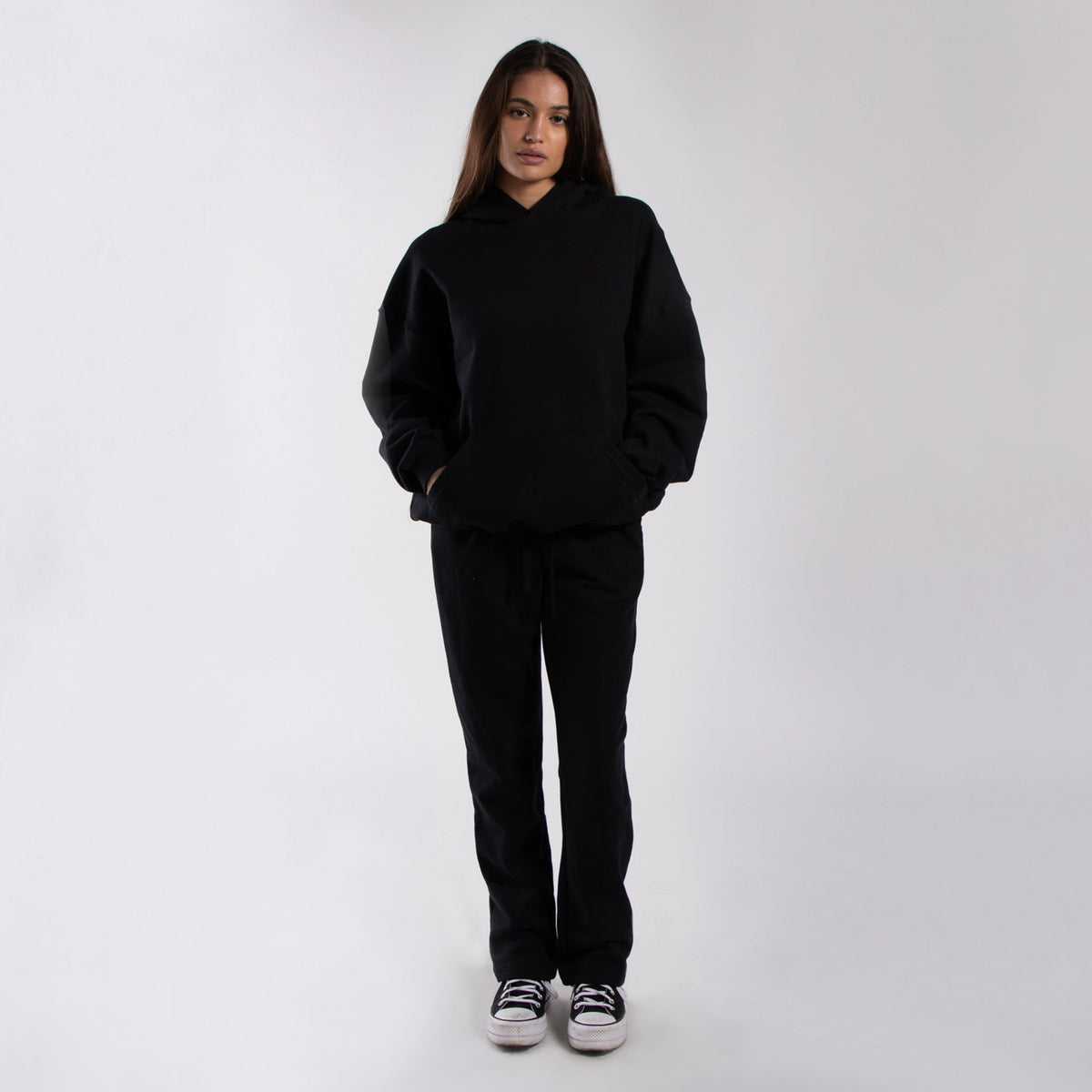 Black oversized fleece hoodie worn with black pants, full front view on a model.