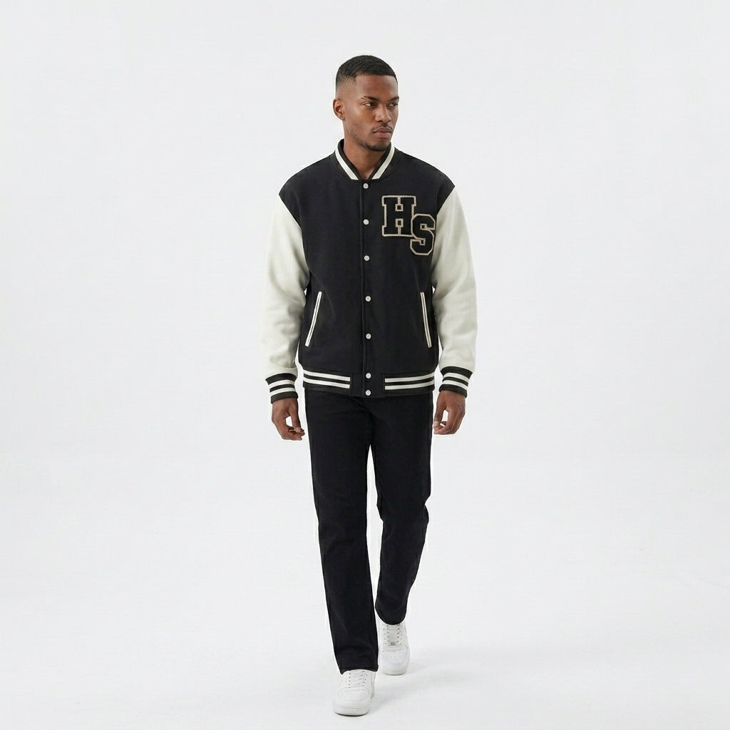 Black and cream Two-Tone Fleeced Varsity Jacket worn with black pants, showing the snap front.