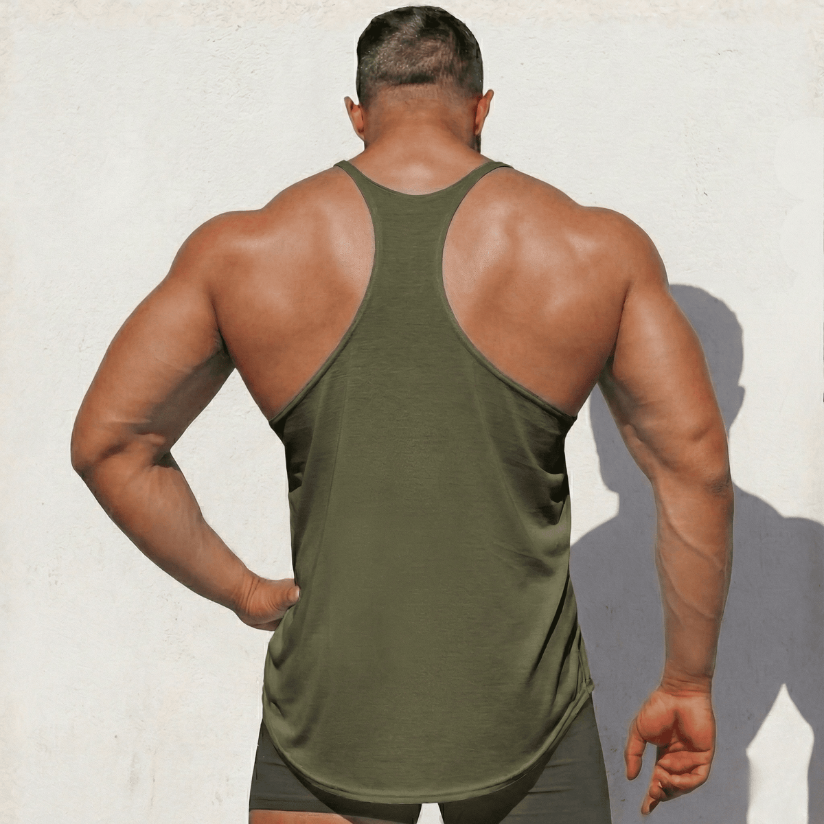 Muted gray-green Stringer Tank Top, model in a back view, showing the racerback cut.
